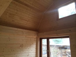 Das Innere einer Holzhütte mit einem Fenster, das im Holzrahmenbau-Verfahren gebaut wurde.