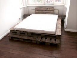 Ein individuell gefertigtes Bett aus Paletten in einem Raum.