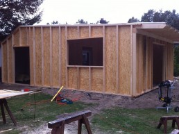 In einem Hinterhof wird ein Holzschuppen im Holzrahmenbau-Verfahren gebaut.