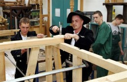 Team Mitglieder arbeiten an einem Holzrahmen in einer HolzBAU-Werkstatt