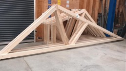 Ein Holzbau-Rahmen steht in einer Garage.